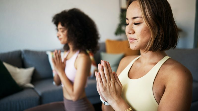 Women, fitness friends and meditation with namaste or prayer hands, mindfulness, wellness and peace